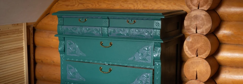 Grüne Kommode mit floralen Verzierungen